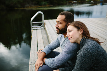 Black and white couple cuddling at the lake