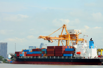 Large container ship with crane are loading in port.