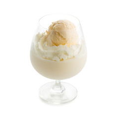 Glass of vanilla milkshake with vanilla ice cream topping isolated on white background