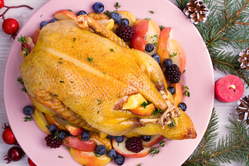 Whole duck with apples, berries and thyme, overhead. Winter holidays decorations, overhead, horizontal