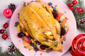 Christmas duck with apples, berries and thyme. Winter holidays decorations, overhead, horizontal