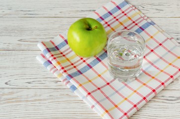 Glass of water with green apple