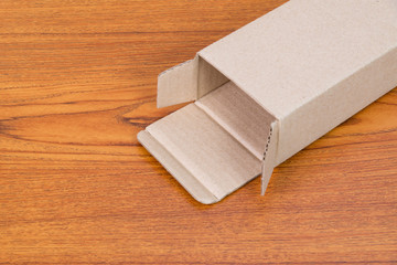 Empty opened brown cardboard box or tray for mock up on the wooden table with copy space.