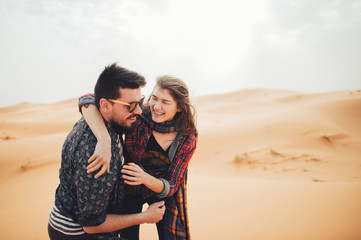 Fototapeta na wymiar Loving couple in the Sahara Desert. Morocco.