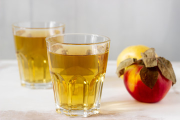 Apple juice in glasses and fresh apples on a wooden background. Rustic style.