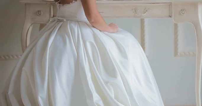 bride sits in front of the mirror / looks at the reflection