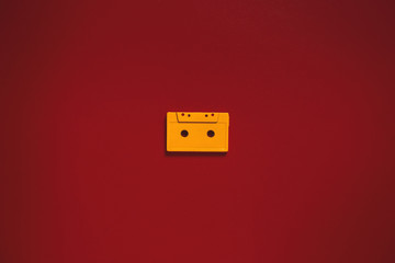 Yellow Audio Cassettes Tapes On Red Background In Center, Top View. Creative Concept Of Retro Technology