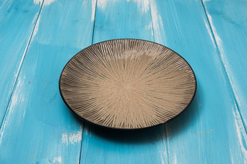 Round plate on blue wooden table with perspective