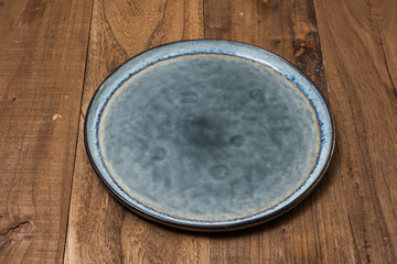 Plate on brown wooden background side view