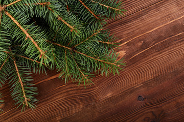 Christmas fir tree on a wooden board. Green spruce branches as a textured background. Green spruce, white spruce, blue spruce.