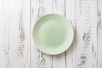 Green Plate on white wooden background