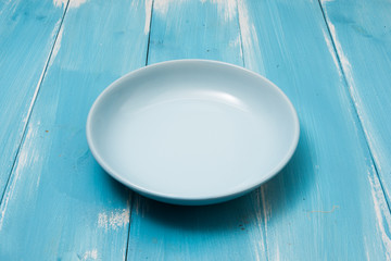 Round plate on blue wooden table with perspective