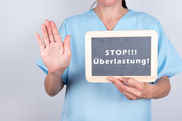 Altenpflegerin mit Schild Überlastung