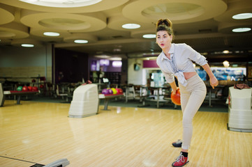 Girl with bowling ball on alley played at bowling club.
