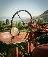 a vintage tractor parked in a vineyard