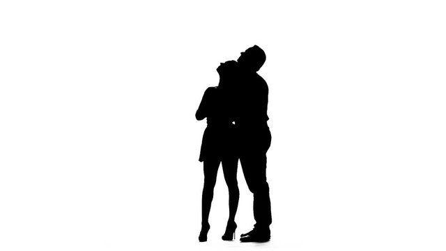 Loving couple kisses and dances together. Silhouette. White background. Slow motion