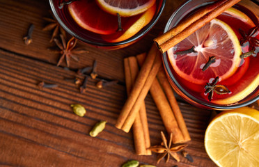 Autumn warming drink. Hot mulled wine, with lemon, anise, cinnamon, cloves, cardamom. Autumn dark still life. Mulled wine with slice of lemon and spices.