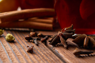 Autumn warming drink. Hot mulled wine, with lemon, anise, cinnamon, cloves, cardamom. Autumn dark still life. Mulled wine with slice of lemon and spices.