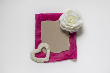 St. Valentine's Day background. White rose, handmade white heart and a piece of paper