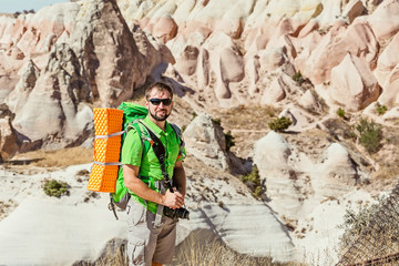 A young outdoors man traveler watching the incredible deserted landscapes of the Goreme National Park in Cappadocia