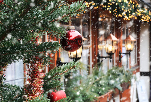 Christmas Street Decorations And Falling Snow - Red Ball, Fir And Bokeh Lights