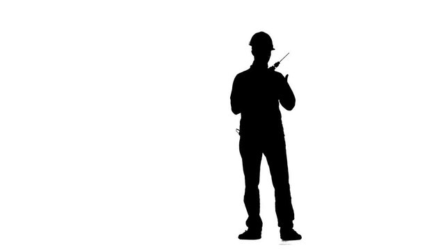 Engineer in a helmet works as a drill. Silhouette. White background