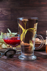 linden tea on a background of dried lime flowers, lemon balm and St. John's wort