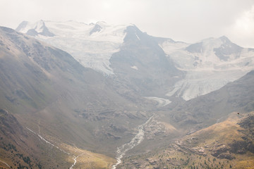 Fototapeta premium montagna innevata con fiume e alberi verdi