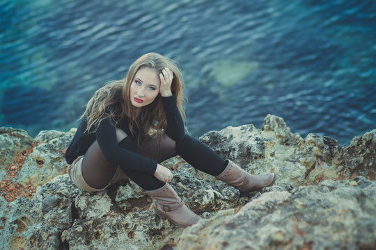 Seductive Sexy Lady Girl With Romantic Pout Red Lips And Pinky Cheeks Wearing Stylish Jacket Dress And Shorts With Autumn Boots Posing At Rocky Beach Sea Side With Make Up On Face I Romantic Episode