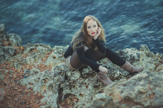 Seductive Sexy Lady Girl With Romantic Pout Red Lips And Pinky Cheeks Wearing Stylish Jacket Dress And Shorts With Autumn Boots Posing At Rocky Beach Sea Side With Make Up On Face I Romantic Episode