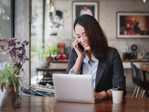 Asian business woman with laptop happy and smile concept success work
