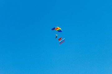 a parachutist jump against the blue sky