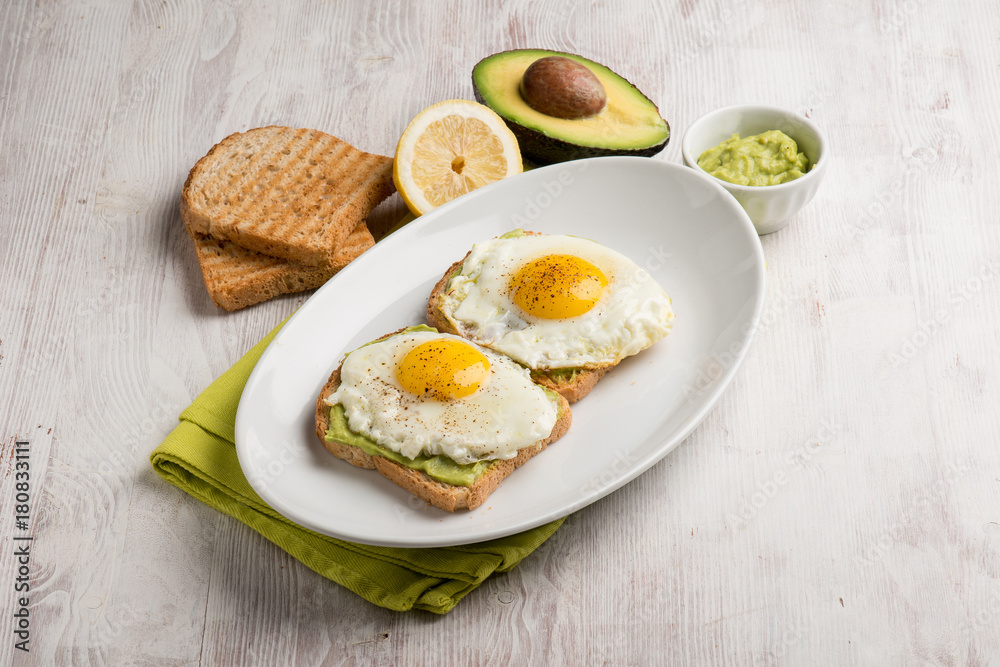 Poster eggs over avocado cream and toasted bread