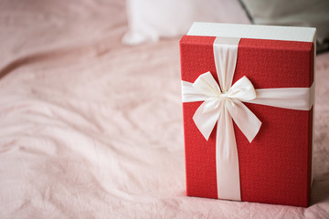 Red gift box with white ribbon.