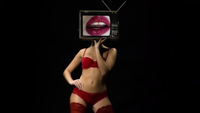 amazing woman in red lingerie dancing and posing with a television as a head. the tv is has video of lips moving