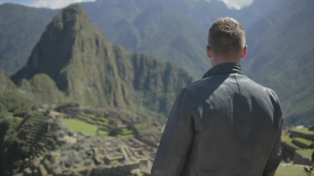 Man steps into frame and enjoys the view at Machu Picchu.