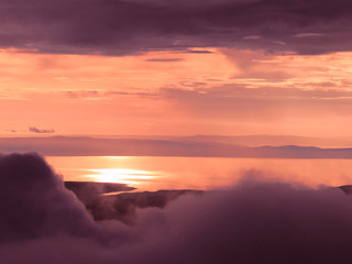 Coucher de soleil sur un lac vue de la montagne, nuages