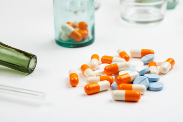 Different medications and pills with vintage pharmacy bottles on a white background
