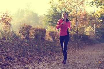 Beautiful young woman running at the lake