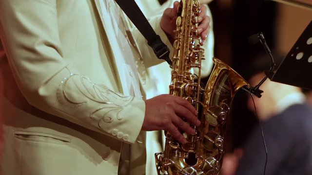 A saxophonist in a white suit. The middle plan.