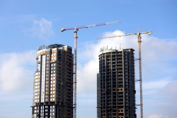 Fototapeta na wymiar Work of construction cranes on high-rise apartment houses