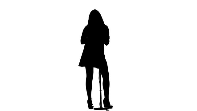 Girl sings lyrical songs and dances. White background. Silhouette