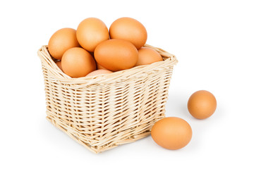 Wicker basket of eggs isolated on white background close-up