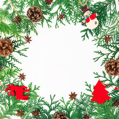 Christmas border frame of winter trees, pine cones and decoration on white background. Winter concept. Flat lay, top view