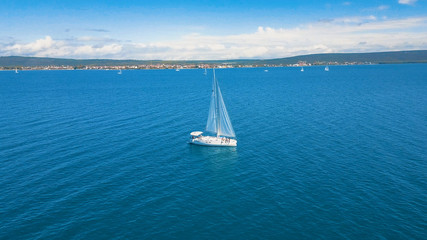 Aerial view of yacht sailing near beautiful Islands. Beautiful clouds in the background. Luxury yacht in the sea.
