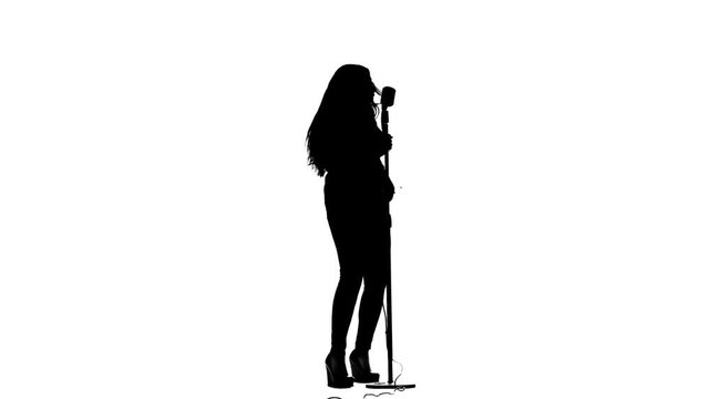 Vocalist performs incendiary songs in a microphone. White background. Silhouette. Slow motion