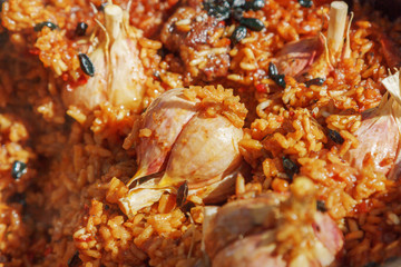 Preparation of pilaf on fire. Tourist bowler with food on bonfire, cooking in the hike, outdoor.