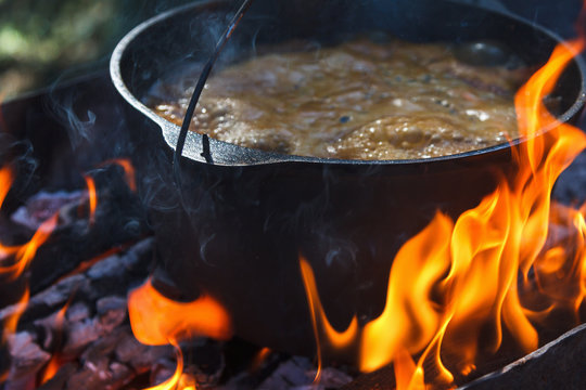 Tourist Bowler With Food On Bonfire, Cooking In The Hike, Outdoor Activities. Preparation Of Pilaf.