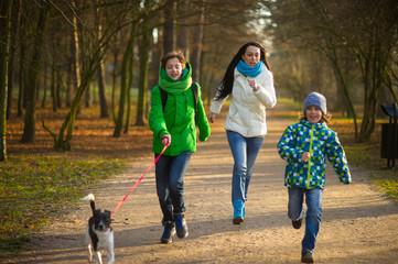 Mother and two sons having fun in autumn Park.