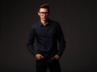 Obraz premium Young sexy man portrait of a confident businessman on a black background. Ideal for banners, registration forms, presentation, landings, presenting concept.